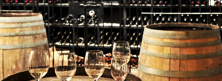 Allée chaleureuse et accueillante d'une boutique de vin (caviste) avec des étagères de bouteilles de vin bien organisées.